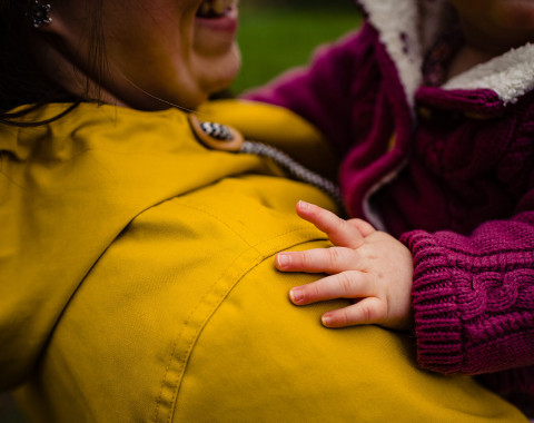 A parent holding a child after attending the TALKWORKS wellbeing for parenthood workshop.